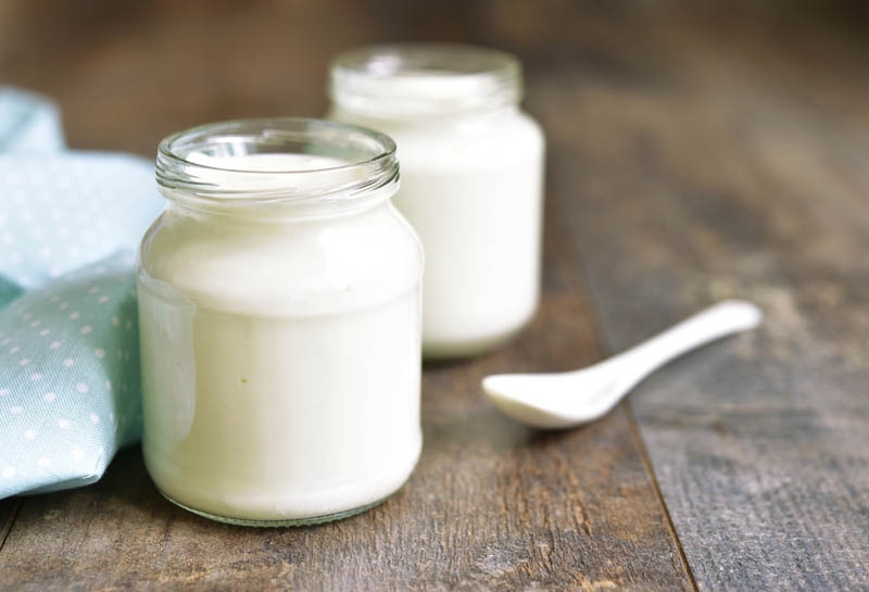 two jars of yogurt, a source of probiotics containing active, live cultures