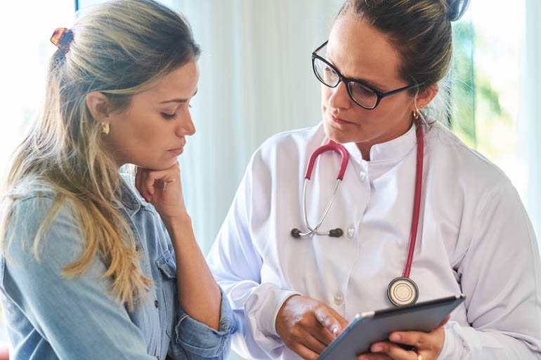 woman consulting her pharmacist about her genetic assessment results.