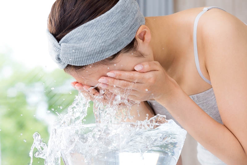 Woman washing her face. Cleansing facial products for a deep and nourishing clean.