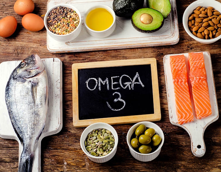 A table full of Omega 3 EPA rich foods including raw fish, olives, avocado, almonds, eggs and more 