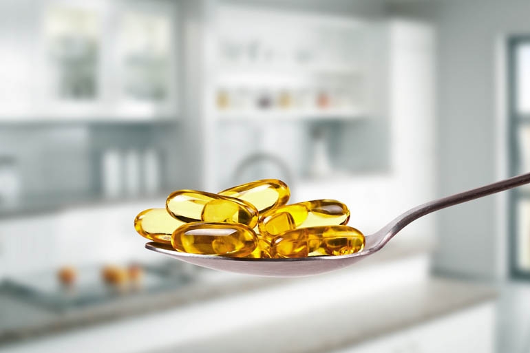 A spoon full of Fish Oil pills in a pharmacy