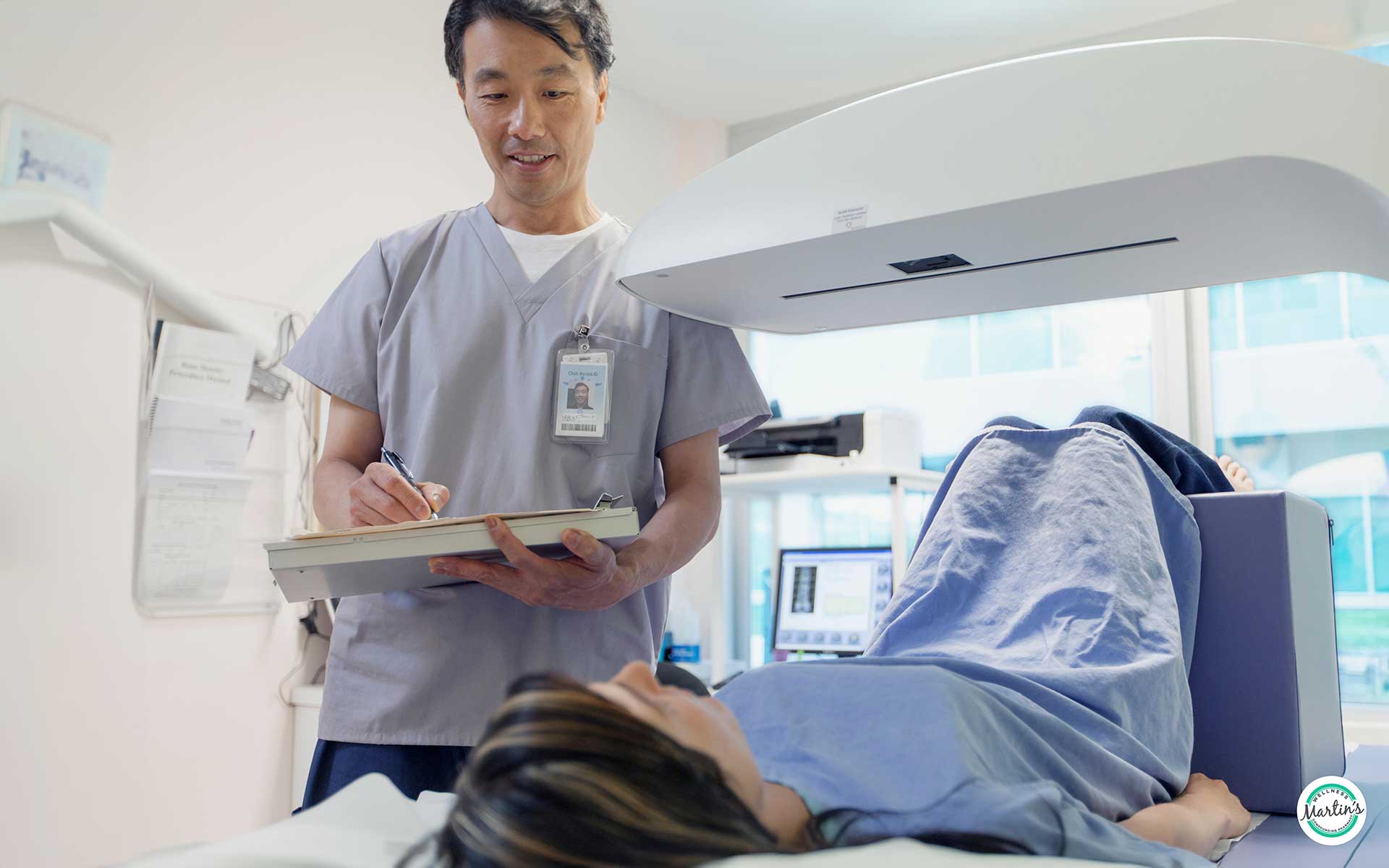 A doctor holding a checklist and performing a bone density checkup on a female patient