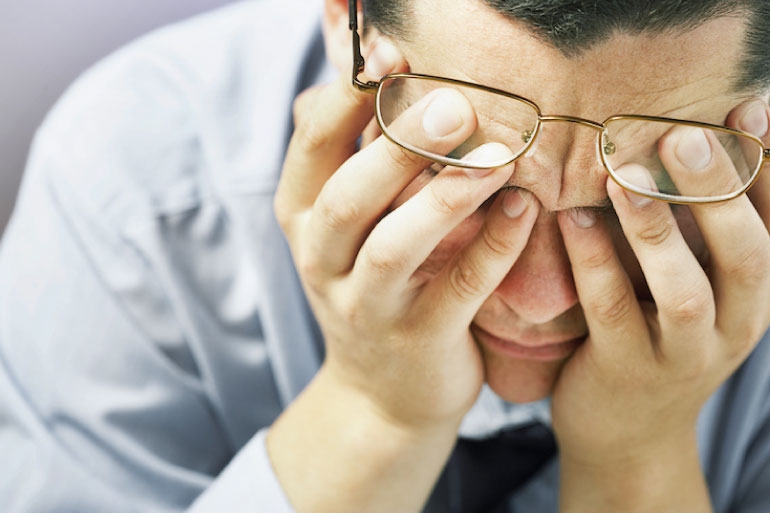 Man with his head in his hands experiencing neurotransmitter imbalance